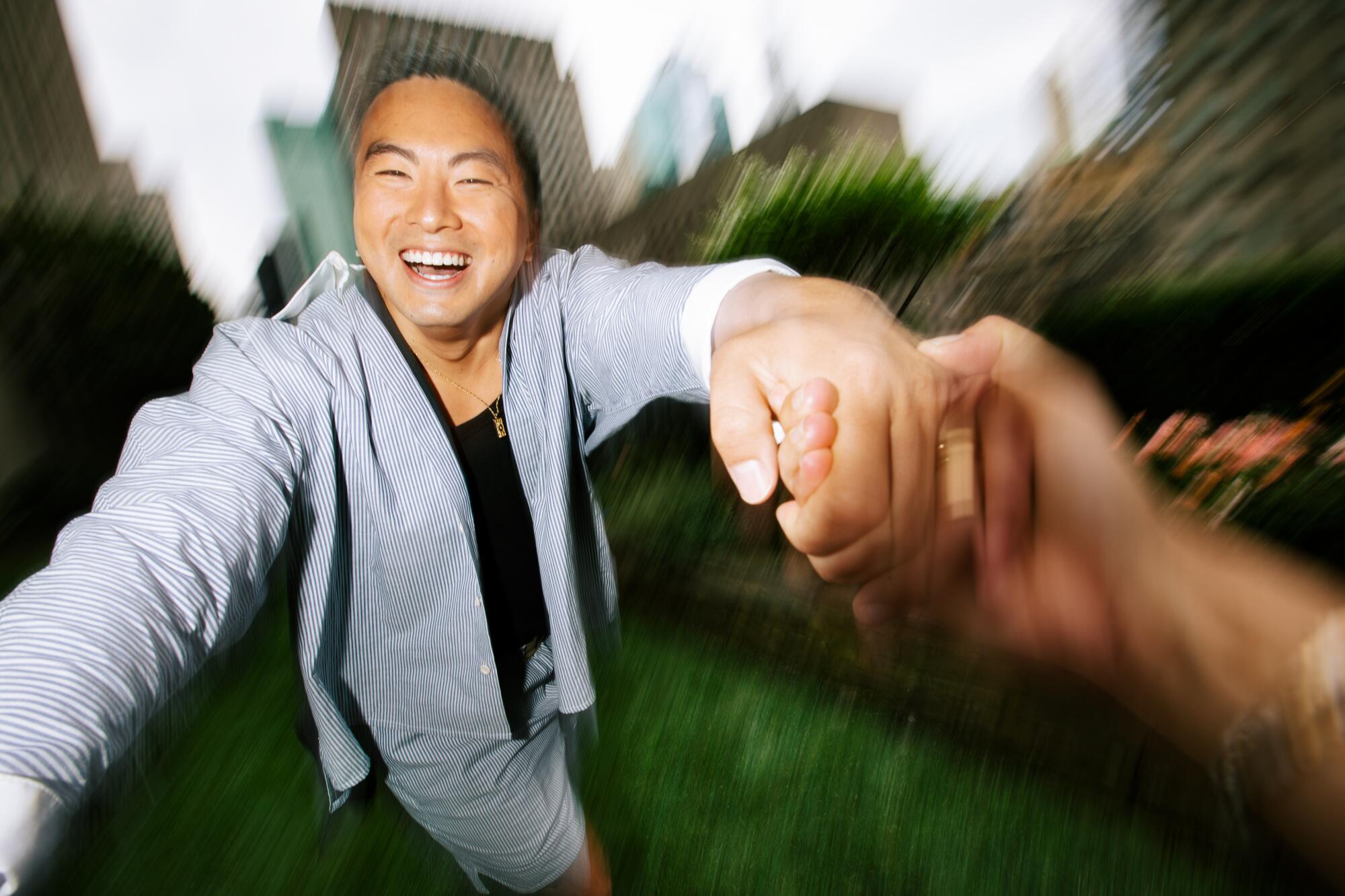 A man laughs as he swirls against a blurred background.
