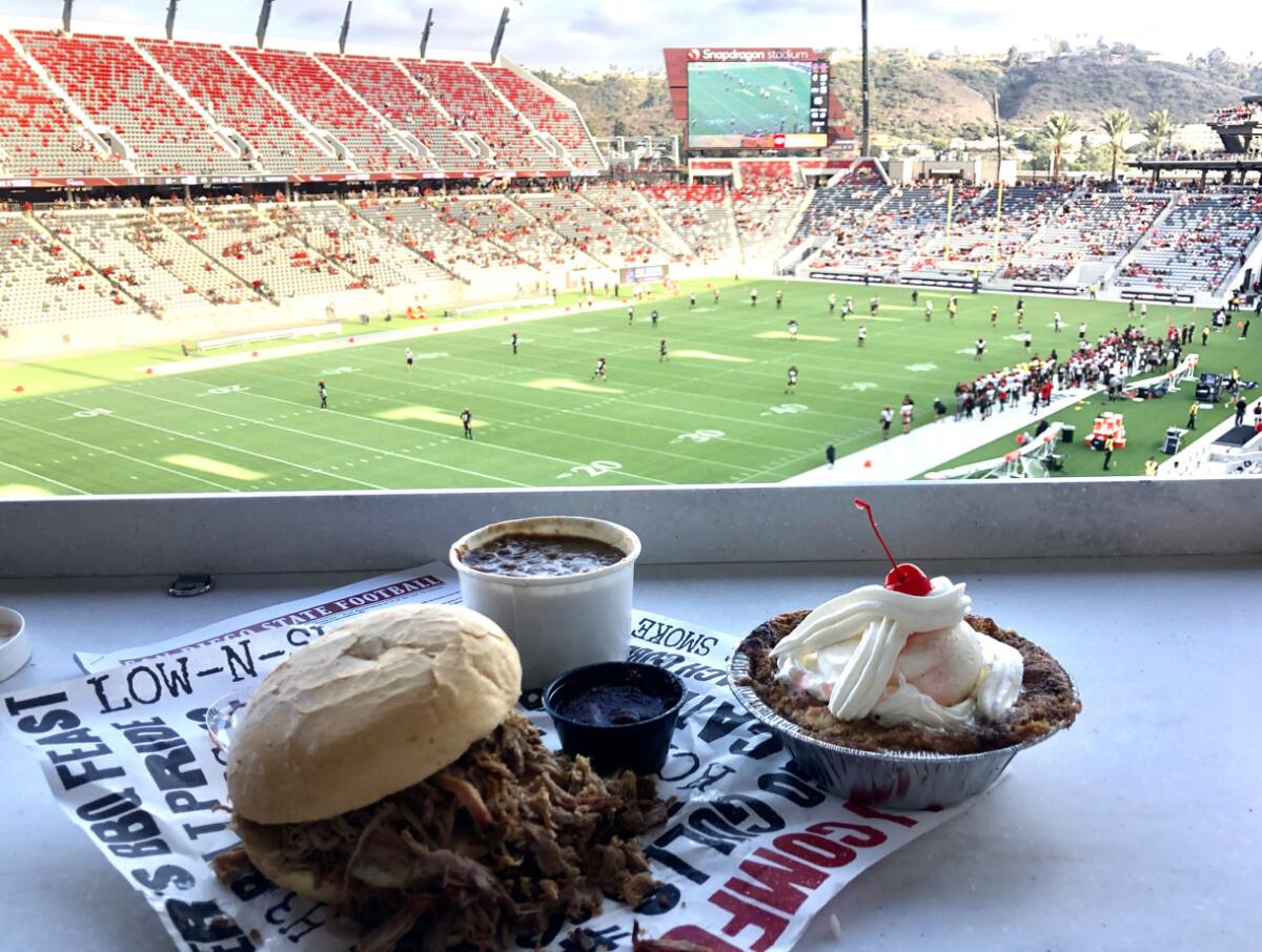 Signature offerings at Snapdragon Stadium from Cali BBQ include a pulled pork sandwich, wedding beans, wicked peach cobbler.
