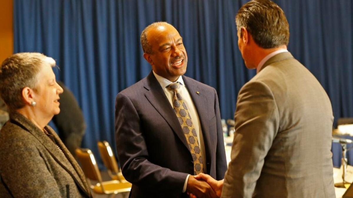 Gary May, center, a Georgia Tech dean, greets University of California Regent Eloy Ortiz Oakley, right, and UC President Janet Napolitano, left, after the regents voted to select May as the next chancellor of UC Davis.