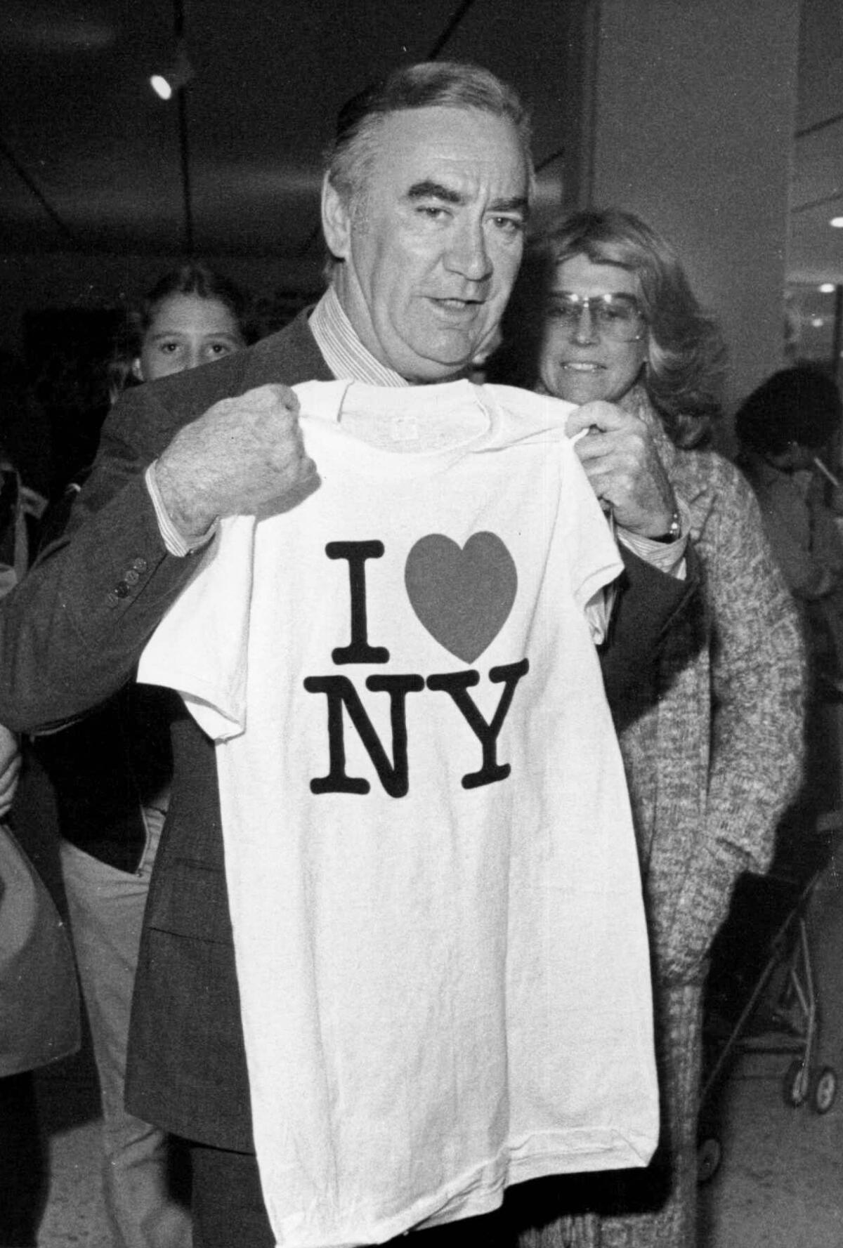 New York Gov. Hugh Carey holds up an "I Love New York" T-shirt in 1977.