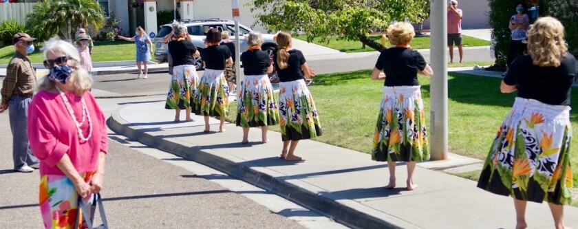 Hula dancers perform on the sidewalk in front of hula teacher Christinia Lee's house to celebrate her 102nd birthday.