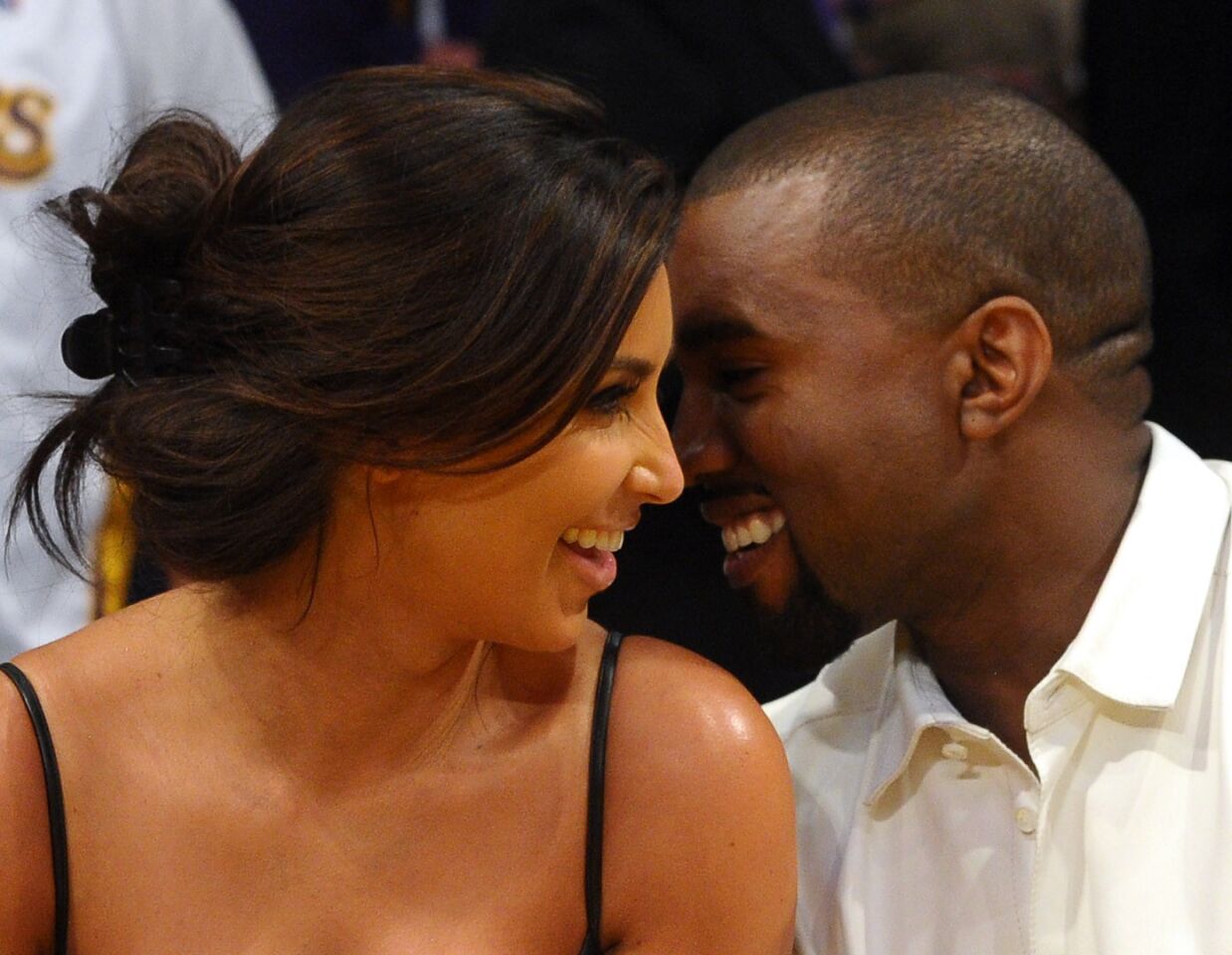 Kim Kardashian and Kanye West talk in their courtside seats before the Lakers take on the Denver Nuggets on May 12, 2012, at Staples Center in Los Angeles.