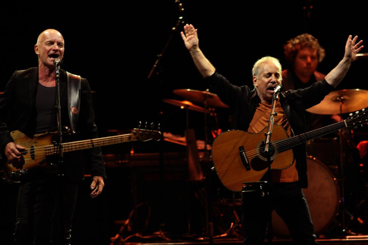Sting, left, and Paul Simon perform a joint concert Saturday night at the Forum in Inglewood.