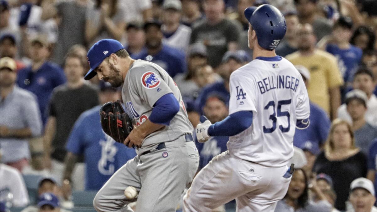 Cubs pitcher Brian Duensing drops the ball, allowing Dodgers first baseman Cody Bellinger to reach base.