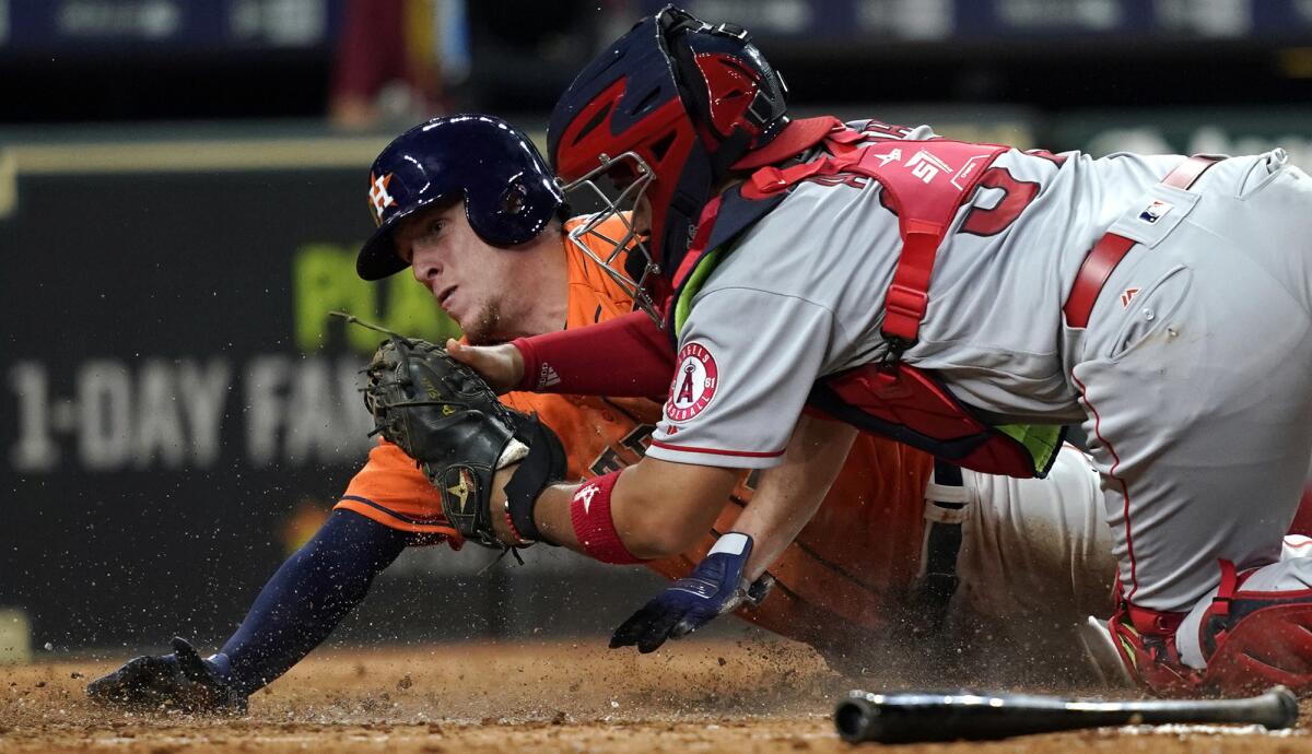 Houston's Myles Straw scores as Angels catcher Francisco Arcia tries to apply the tag during the eighth inning Friday