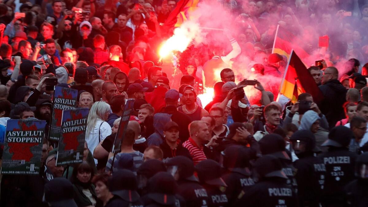 Right-wing demonstrators light flares in Chemnitz, Germany, after a 35-year-old German was killed in an attack.