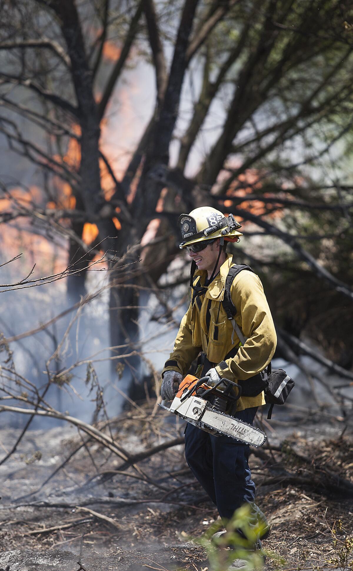 Costa Mesa Firefighter Mike Ruhl prepares to cut away brush while battling a 3-acre brush fire at Talbert Regional Park in Costa Mesa on Friday, May 9. (Scott Smeltzer - Daily Pilot)
