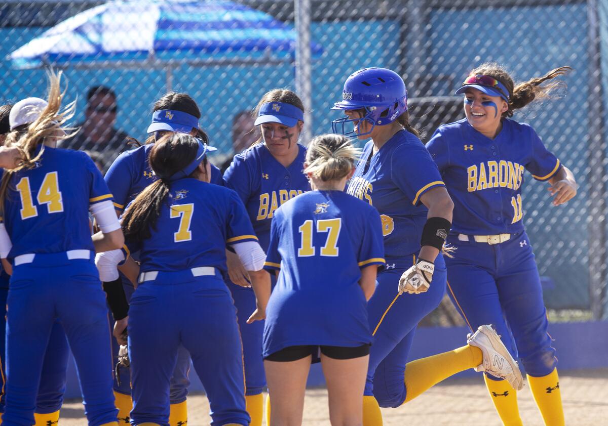 Fountain Valley's Makenzie Butt is mobbed at home plate by her teammates after hitting a solo home run in the fifth inning.