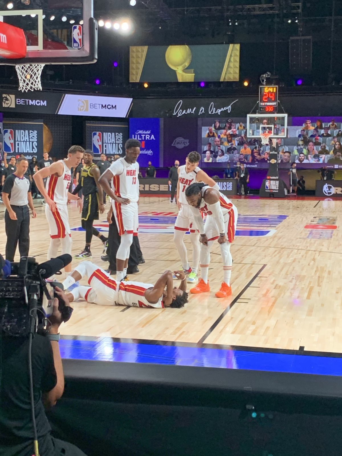 Miami Heat forward Jimmy Butler lies on the court clutching his neck after being hit by Lakers center Dwight Howard.