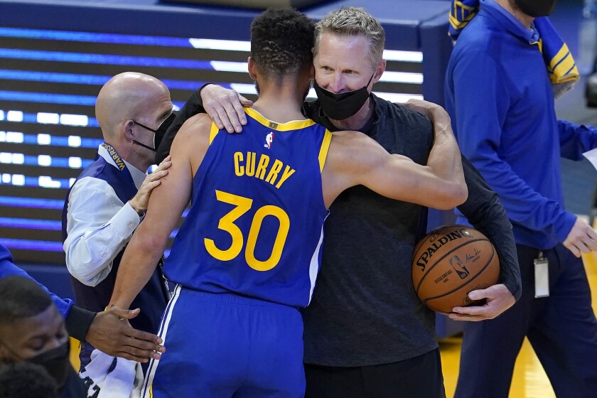Golden State Warriors guard Stephen Curry (30) hugs head coach Steve Kerr after the Warriors defeated the Denver Nuggets in an NBA basketball game in San Francisco, Monday, April 12, 2021. (AP Photo/Jeff Chiu)