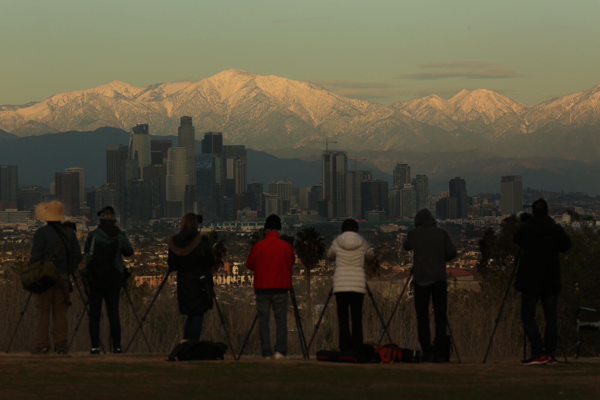 Photographers line up to photograph the snow capped San Gabriel mountains and the Los Angeles skyline