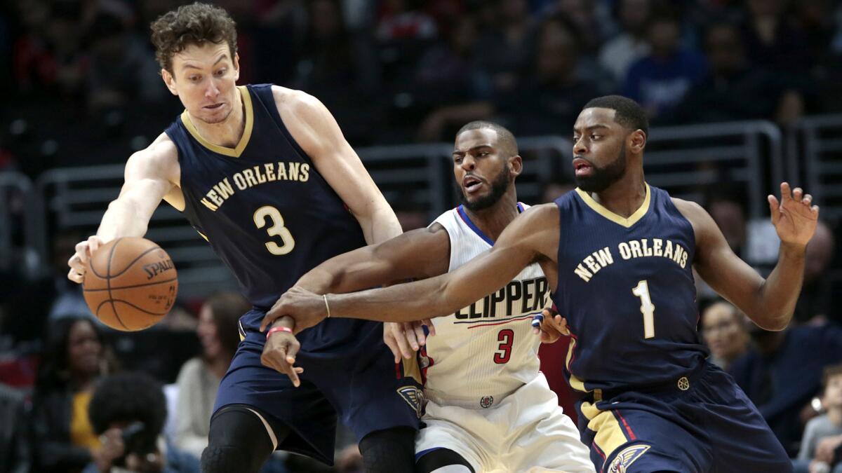 Clippers guard Chris Paul steps between Pelicans center Omer Asik, left, and Tyreke Evans to make a steal during the first half Sunday afternoon at Staples Center.