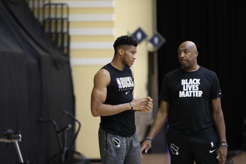 Milwaukee Bucks assistant coach Vin Baker, right, talks to two-time MVP Giannis Antetokounmpo during a practice.