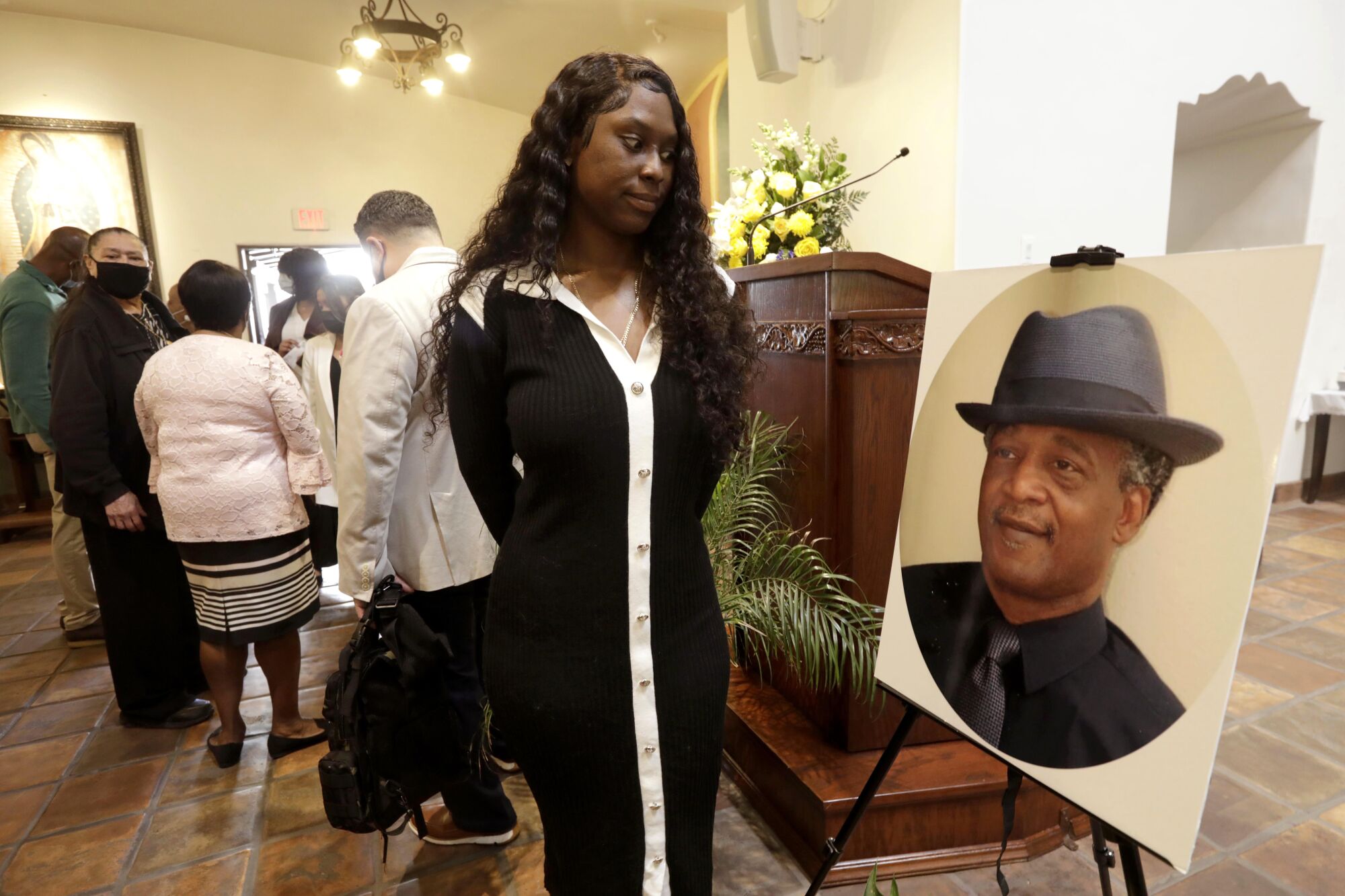 Sha'Ron Berry looks at a photo of Michael Wainwright at the end of a memorial service.
