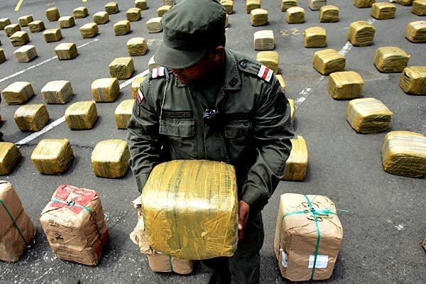 A police officer holds a package of seized marijuana during a news conference at police headquarters in Cali, Colombia. Police said 2.8 tons of marijuana were seized in a raid north of Cali.