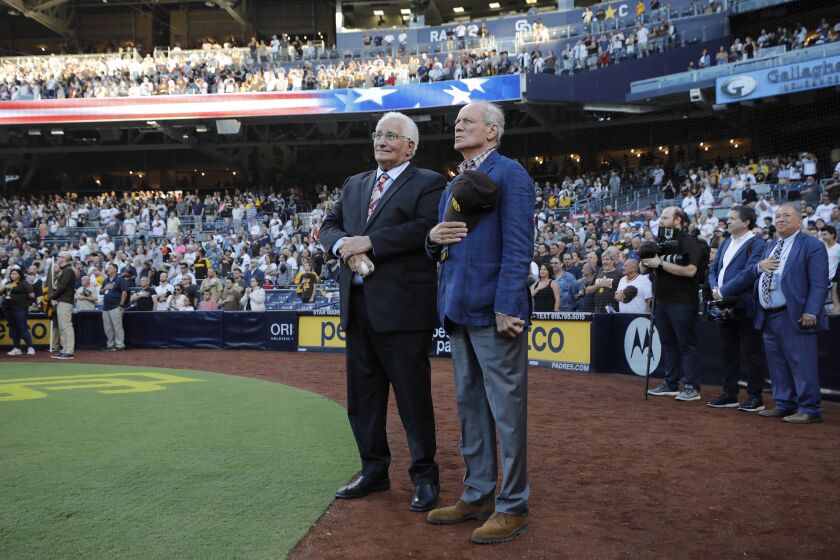 SAN DIEGO, CA - JULY 7: Ted Leitner and Larry Lucchino, who were inducted into the Padres Hall of Fame before a game against the San Francisco Giants, listen to the national anthem at Petco Park on Thursday, July 7, 2022 in San Diego, CA. (K.C. Alfred / The San Diego Union-Tribune)