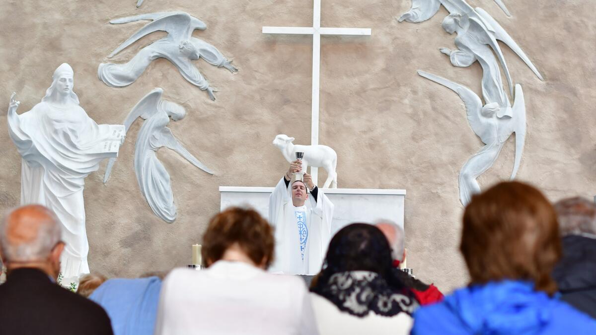 Mass is said at the Apparition Chapel in Knock, in the west of Ireland. The wall behind is said to be the exact location where in 1879 15 locals reported a two-hour-long encounter with the Virgin Mary.