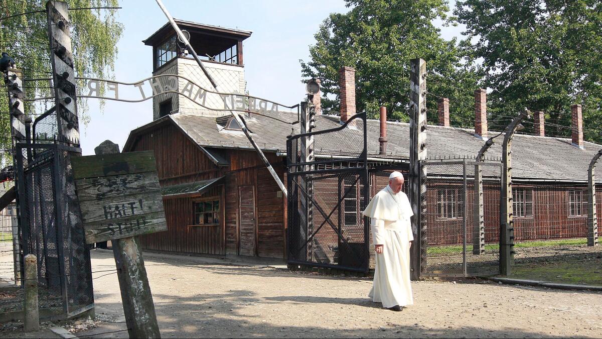 Pope Francis walks through the gate of the former Nazi German death camp of Auschwitz in Oswiecim, Poland, on Friday.