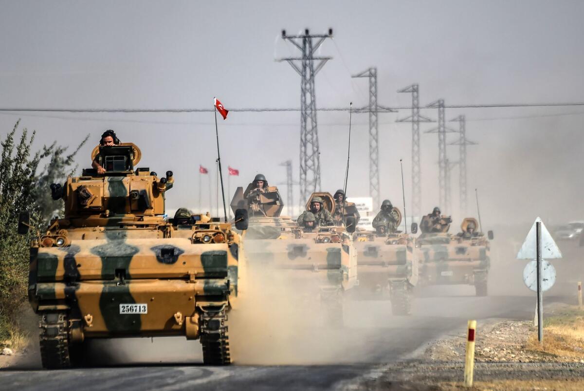 Turkish Army tanks drive to the Syrian Turkish border town of Jarabulus.