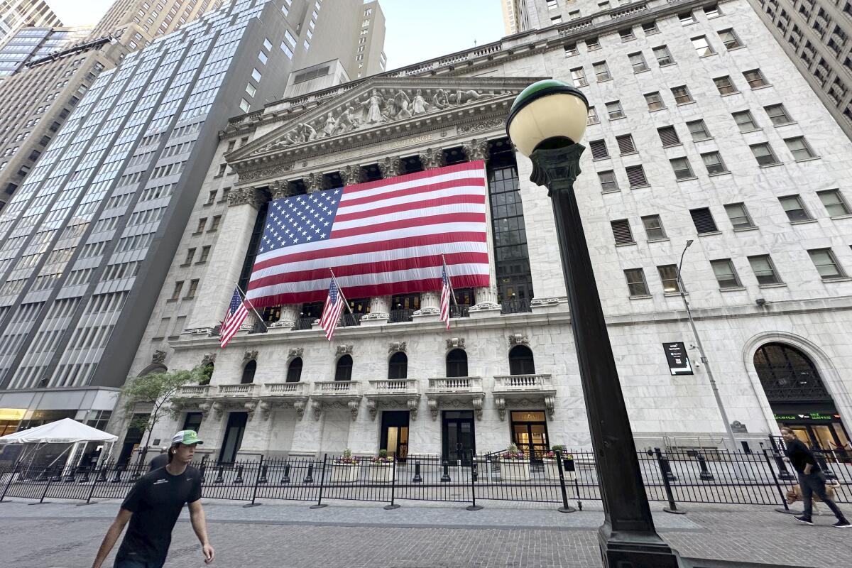 People pass the New York Stock Exchange 