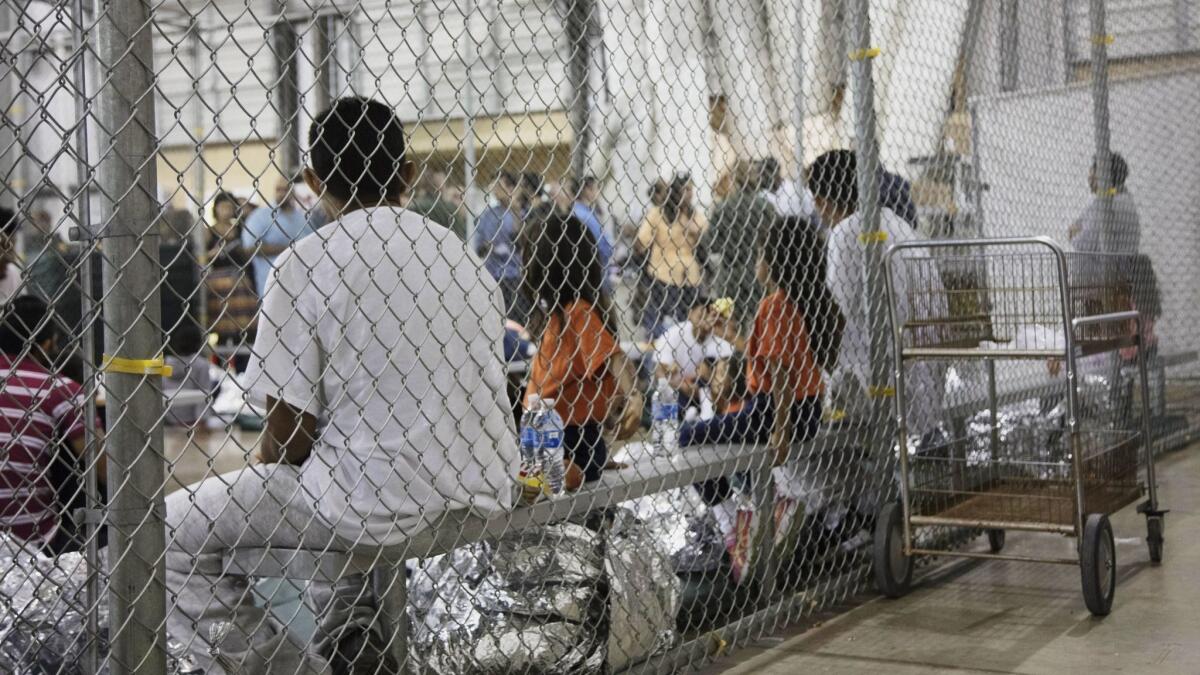 People who've been taken into custody related to cases of illegal entry into the United States sit in one of the cages at a facility in McAllen, Texas, on June 17.