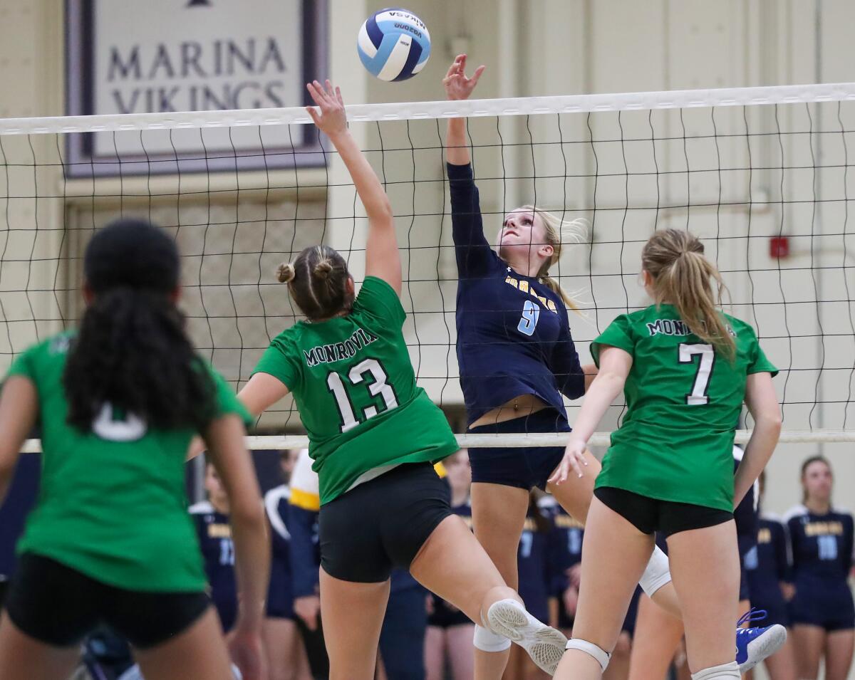 Marina's Jordan Packer wins a battle at the net with Monrovia's Taylor Brandley (13) during a CIF Division 5 playoff match.