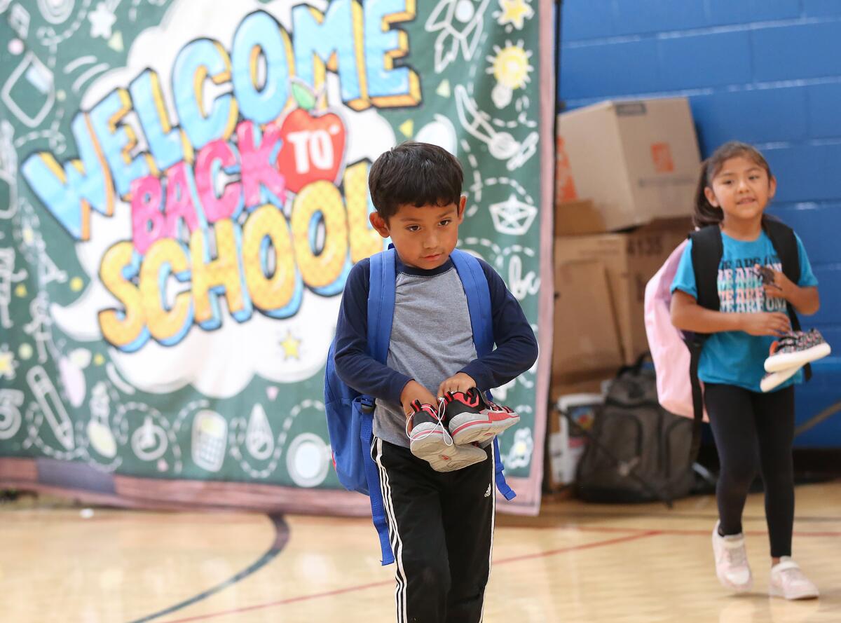 Children happily walk away with new school gear during Monday's giveaway at the Oak View Family Resource Center.