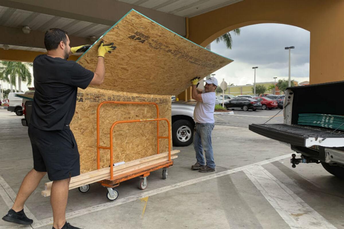 Shoppers load their truck with supplies to board up windows Aug. 29 as they prepare for Hurricane Dorian in Pembroke Pines, Fla.