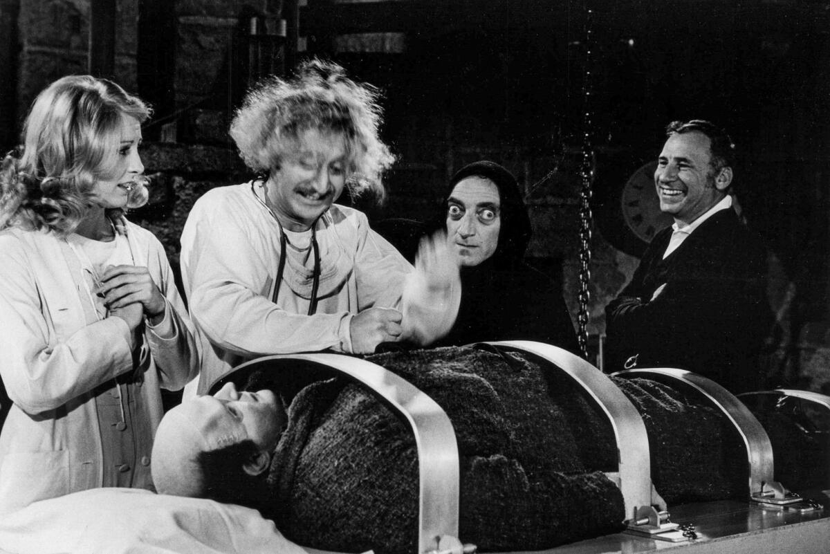 March 27, 1974: On the set of "Young Frankenstein" are from left standing: Actors Teri Garr, Gene Wilder and Marty Feldman, and director Mel Brooks. Lying down is Peter Boyle, who played the monster.