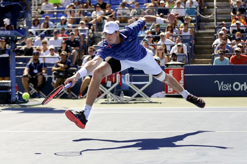 John Isner returns a shot to Jiri Vesely during the third round of the U.S. Open on Saturday.
