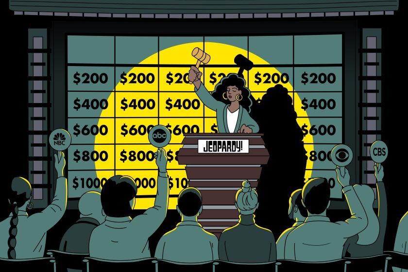 Auctioneer takes bids in front of  a "Jeopardy" game board.