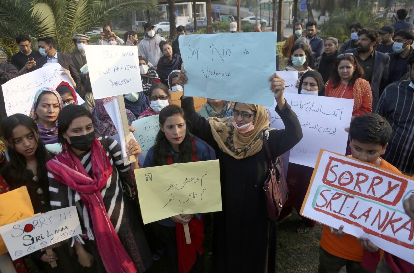 Members of a civil society group participate in a demonstration to condemn Sialkot's lynching incident, in Lahore, Pakistan, Saturday, Dec. 4, 2021. Police arrested 13 suspects and detained dozens of others in the lynching of a Sri Lankan employee at a sports equipment factory in eastern Pakistan, officials said Saturday. (AP Photo/K.M. Chaudary)