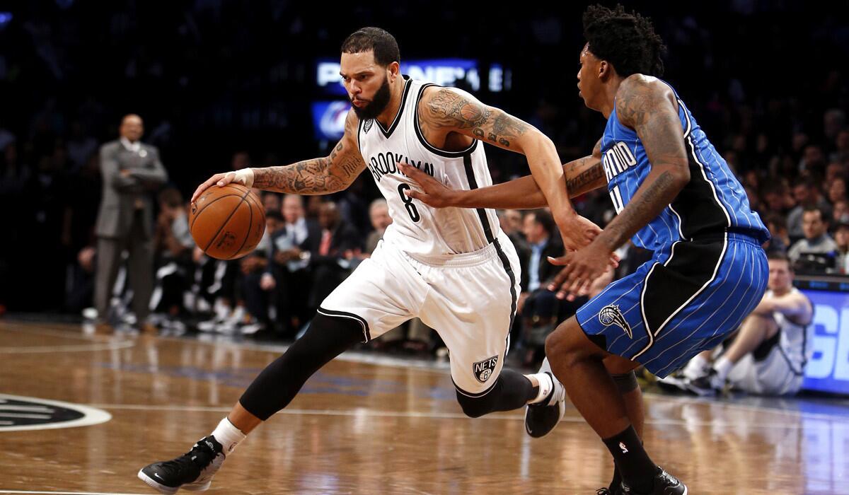 Brooklyn Nets' Deron Williams, left, tries to dribble past Orlando Magic's Elfrid Payton during a game on Nov. 9 2014. Two people with knowledge of the arrangement tell The Associated Press that Williams is set to join the Dallas Mavericks if the point guard clears waivers after reaching a buyout with the Nets. Williams will sign with the Mavericks once he clears waivers Monday, the people said Friday on condition of anonymity because the deal can't become official until Williams clears waivers.