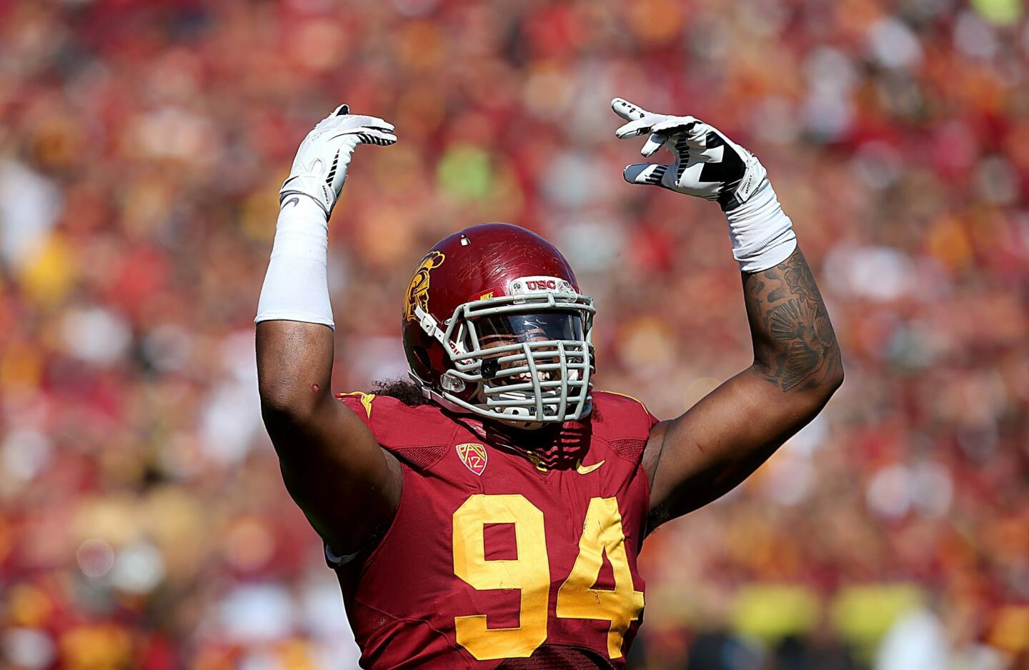 USC defensive end Leonard Williams urges Trojans fans to make noise during the third quarter Saturday at the Coliseum. USC would go on to defeat Utah State, 17-14, in the nonconference game.
