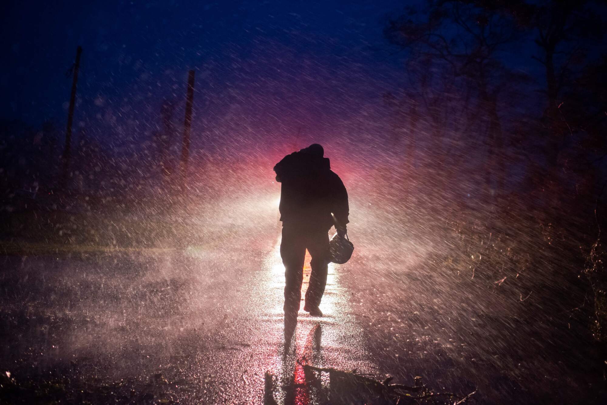 Montegut fire chief Toby Henry walks back to his fire truck in the rain 