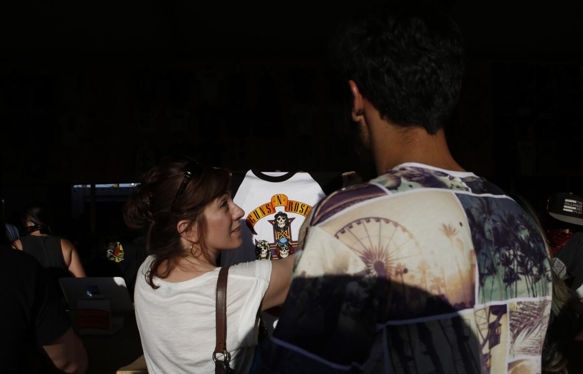 Lorraine Ali helps Abdullah pick out a Guns N' Roses T-shirt at the 2016 Coachella Valley Music and Arts Festival.