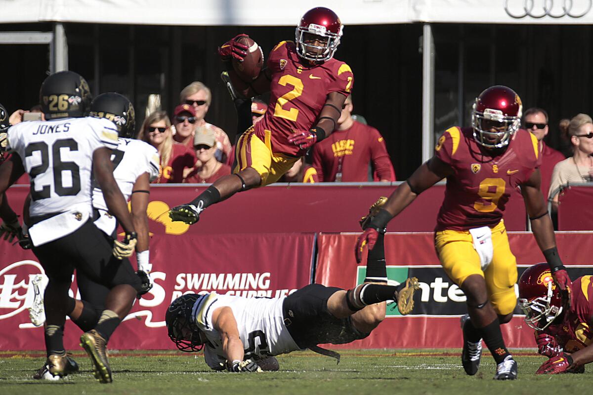 USC kick returner Adoree Jackson leaps over Colorado defender Ryan Moeller as he runs back the opening kick at the Coliseum during a game on Oct. 18.