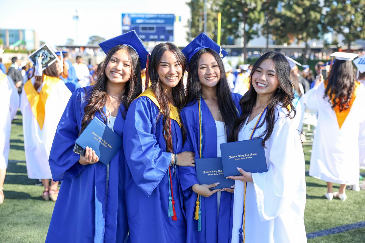Fountain Valley graduates pose with their diplomas after a commencement ceremony on Wednesday at Orange Coast College.