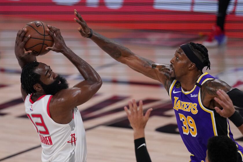 Houston's James Harden looks to pass while being defended by Lakers center Dwight Howard on Friday.