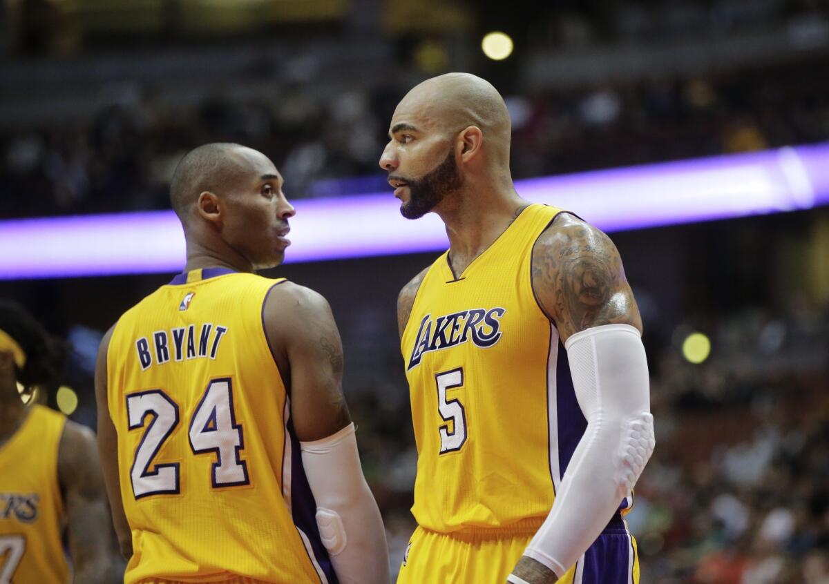 Kobe Bryant and Carlos Boozer helped lead the Lakers to their first win of the season Sunday over the Charlotte Hornets, 107-92.