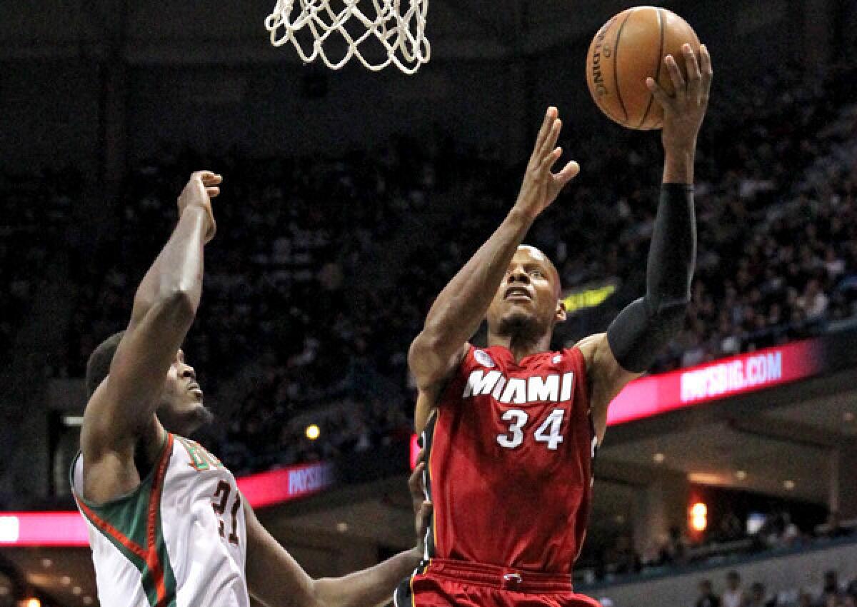 Heat guard Ray Allen scores on a layup agianst Bucks center Samuel Dalembert in the second quarter action of Game 3 on Thursday night in Milwaukee.