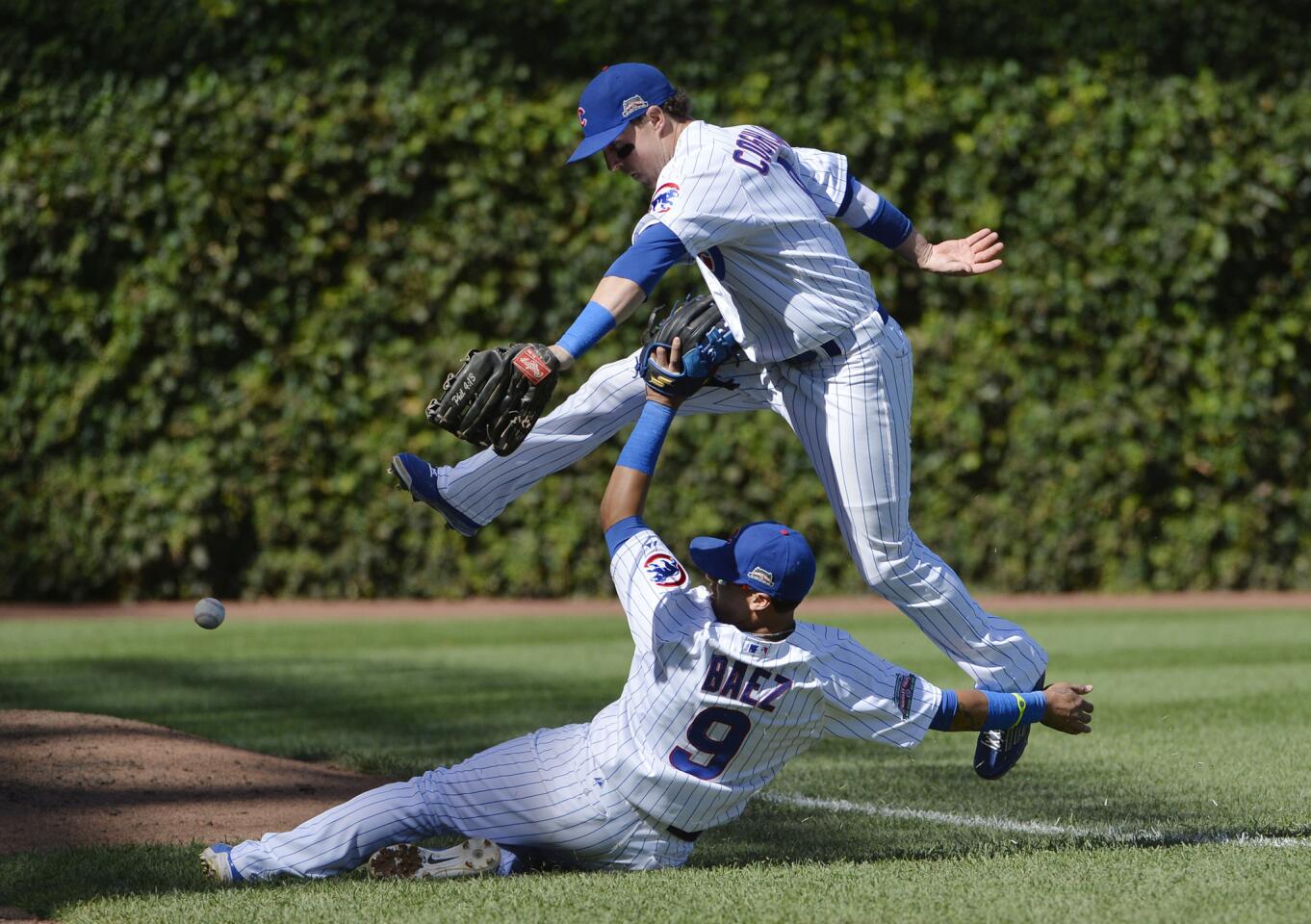 Chris Coghlan and shortstop Javier Baez collide as they go for a pop foul during the eleventh inning.