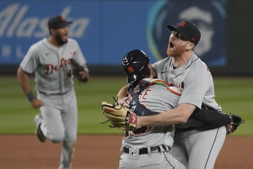 Detroit Tigers starting pitcher Spencer Turnbull, right, hugs catcher Eric Haase as teammates rush in after Turnbull threw a no-hitter in a baseball game against the Seattle Mariners, Tuesday, May 18, 2021, in Seattle. The Tigers won 5-0. (AP Photo/Ted S. Warren)
