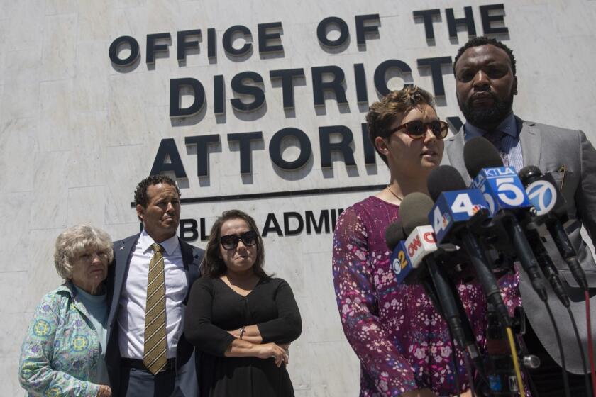 SANTA ANA, CALIF. - JULY 11, 2019: Nyla Williams, 19, the sister of Hannah Williams, who was shot and killed by a Fullerton police officer on the 91 Freeway, speaks at a news conference outside the Orange County District Attorney's Office in Santa Ana, Calif. on Thursday, July 11, 2019. To her right, is the civil rights attorney Lee Merritt, and her family listens in the back from left, grandmother Lynn Williams, father Benson Williams and mother Pilar Looney. (Liz Moughon / Los Angeles Times)