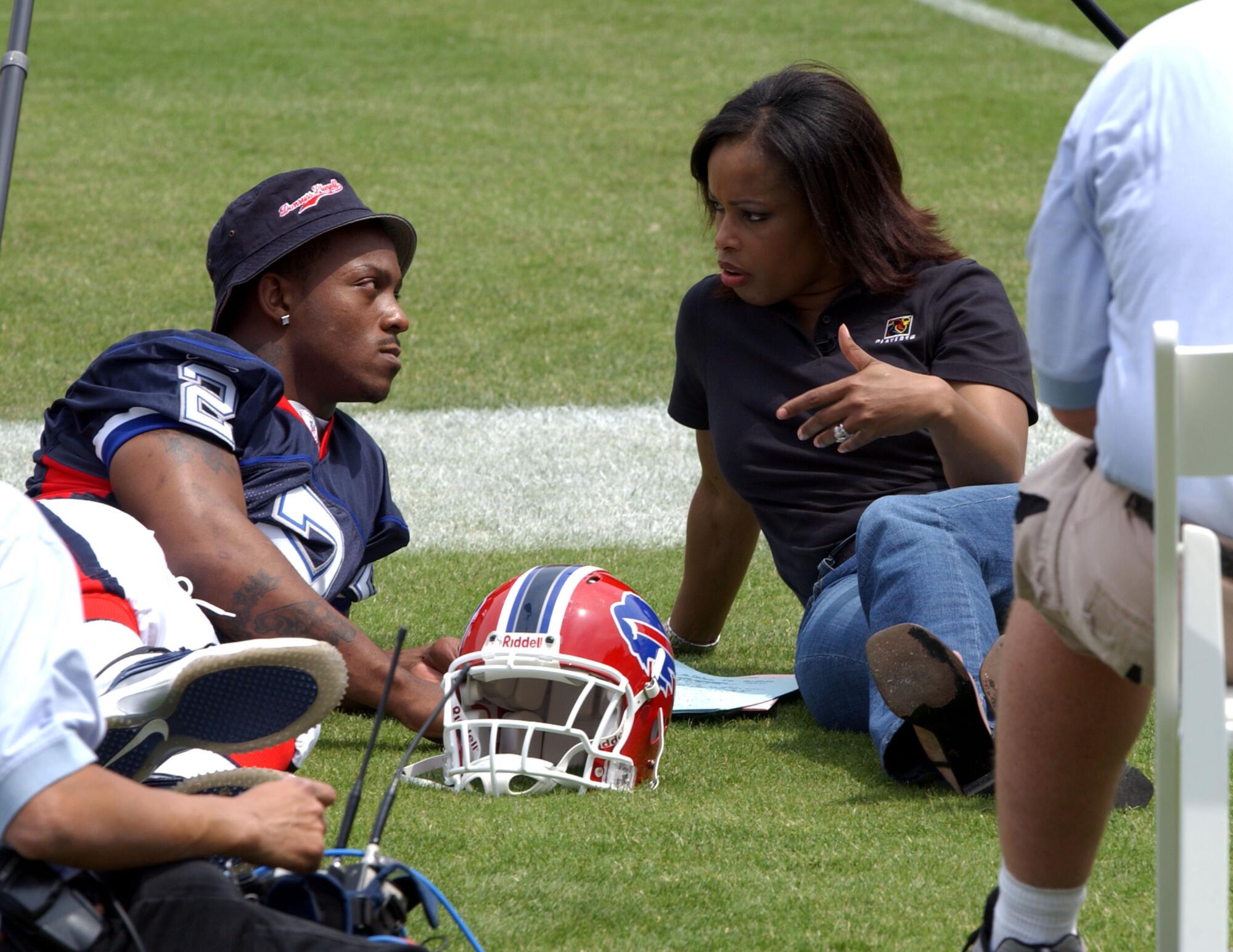 The Bills' Willis McGahee and Fox Sports' Pam Oliver sit on the L.A. Coliseum field during a rookie event.