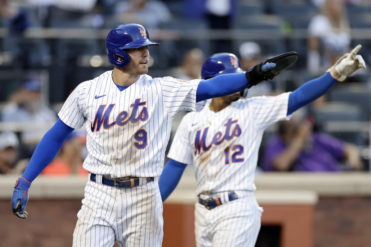 New York Mets' Brandon Nimmo (9) and Francisco Lindor react after Nimmo scored during the seventh inning of the team's baseball game against the Los Angeles Dodgers on Thursday, Sept. 1, 2022, in New York. (AP Photo/Adam Hunger)