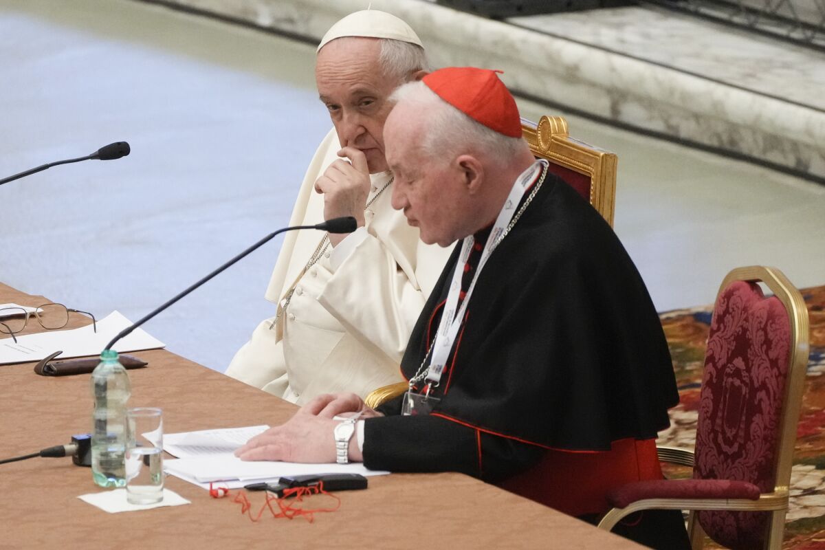 Pope Francis, left, listens to Cardinal Marc Ouellet's opening address as he attends the opening of a 3-day Symposium on Vocations in the Paul VI hall at the Vatican, Thursday, Feb. 17, 2022. (AP Photo/Gregorio Borgia)