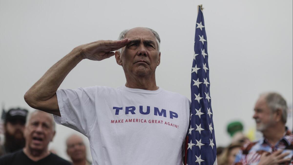 Adrian Asencio, 73, from Redlands, salutes as the National Anthem is played during a rally supporting President Trump near the border.
