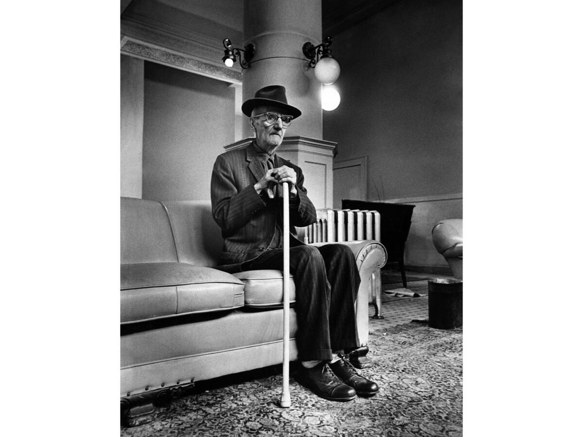 March 16, 1972: Leo Altoonian, 85, waits in lobby of the fire-damaged Barclay Hotel for his turn to get his belongings out of his room.