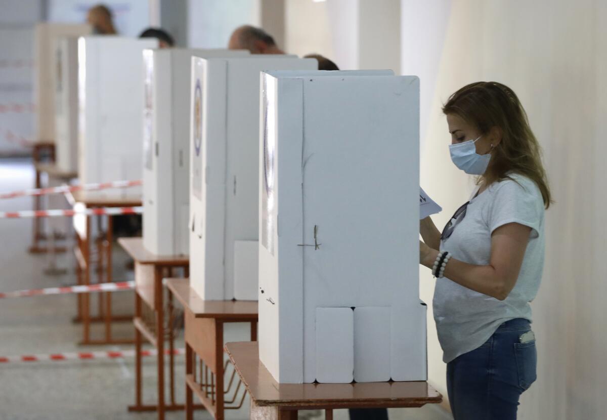 People read their ballot papers at a polling station in Yerevan, Armenia, on June 20.